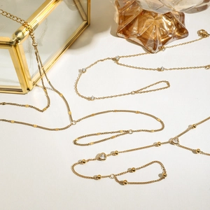 Detail of three gold necklaces with hollow heart pendant and zircon embellishments