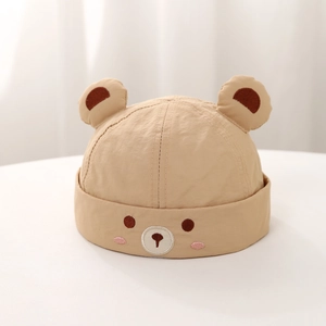 Close-up of cute bear embroidery and 3D ears on beige baby brimless docker cap