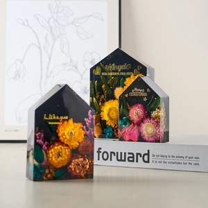 House-shaped resin flower bookends set with dried sunflowers and gold lettering
