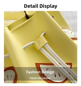 Detail of yellow drawstring bucket bag with decorative orange semicircular fruit patches