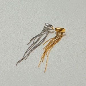 Detailed close-up of gold and silver tassel earrings with high-polish metal finish