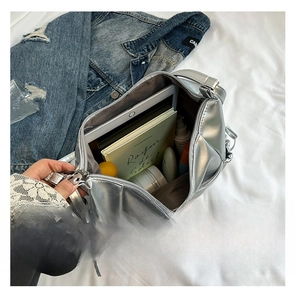 Detail shot of spacious silver metallic bag interior holding a tablet and daily items