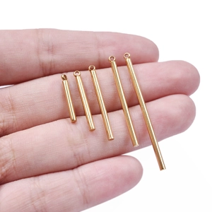 Handheld view of five gold stainless steel cylindrical pendant bars for DIY jewelry making