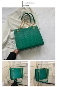 Macro detail of green crocodile texture PU leather handbag with golden chain strap