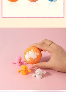 Detailed view of bath bombs in orange, raspberry, and ocean scents with cartoon toys
