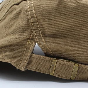 Macro detail of cotton beret featuring vintage metal buckle and reinforced stitching