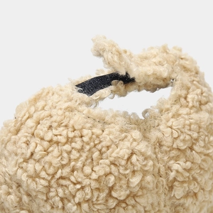 Close-up of beige fleece baseball cap texture and black adjustable strap at the back