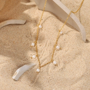 Detail view of 18K gold stainless steel chain with pearls on white ceramic fragments