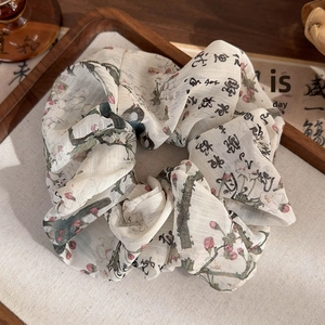 Detail of calligraphy print and ink painting motif on soft oversized fabric scrunchie