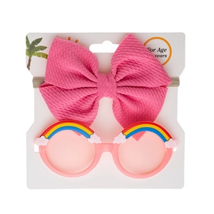Close-up of pink bow headband and rainbow round sunglasses set for baby girls