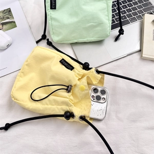 Dettaglio di borse a tracolla minimaliste in nylon con coulisse in giallo e verde