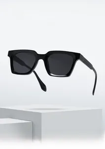 Minimalist black square acetate sunglasses displayed on a geometric pedestal with a clean look
