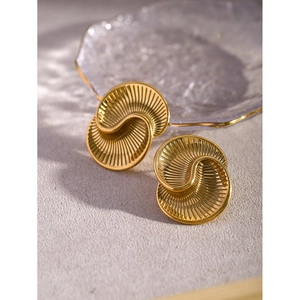 Detail of 18k gold plated stainless steel earrings with spiral texture on a glass tray