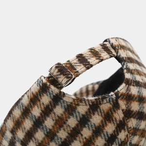 Detailed view of plaid baseball cap with adjustable strap and silver metal buckle closure