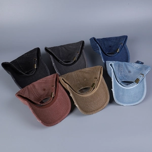 Vista dettagliata di cappellini in denim consumato con bordi sfilacciati e fibbie in metallo