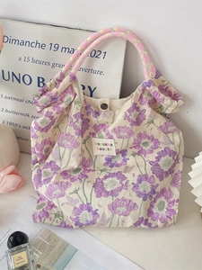 Floral canvas tote bag with woven handles shown in a French aesthetic lifestyle setting