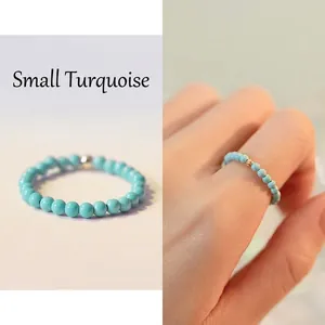 Minimalist turquoise beaded ring with a gold spacer bead and elastic band