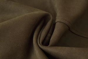 Macro view of dark brown faux suede fabric showing soft texture and matte finish