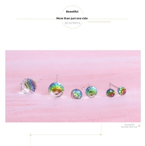 Macro detail of S925 silver stud earrings set featuring iridescent crystal balls