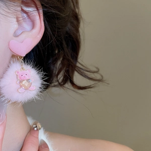 Detail of pink flocked heart stud with plush pompom and rhinestone bear charm on model