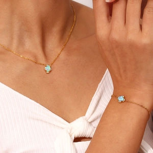 Detailed view of an 18K gold plated flower necklace with white opal and zircons