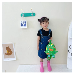 Detail of green kids dinosaur backpack with orange patterns for preschool outings