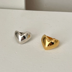 Detailed view of 3D heart-shaped rings in polished gold and silver metallic finishes