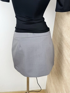 Detail view of a gray mini A-line skirt with a slim fit design on a model