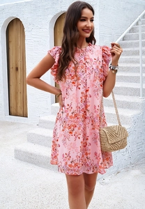 Robe sans manches à imprimé floral rose avec volants sur un escalier méditerranéen