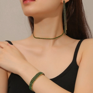 Detail of green emerald choker, long tassel earrings, and bracelet set for women