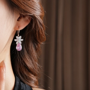 Gros plan de boucles d'oreilles poires roses avec design de fleur en zircon sur mannequin
