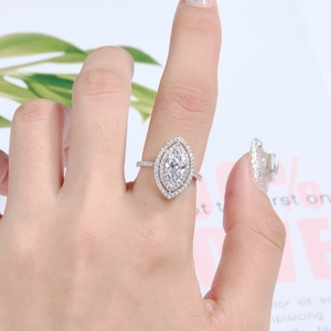 Macro shot of S925 silver ring featuring marquise-cut diamond and pavé-set band on finger