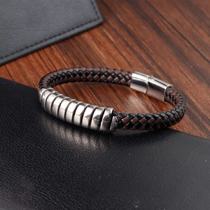 Detail of woven brown and black leather bracelet with silver metal ring and clasp