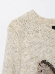 Close-up of beige wool blend knit sweater neck detailing and chunky ribbed texture