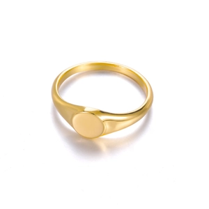 Detailed view of a minimalist golden signet ring with a round flat top and smooth finish