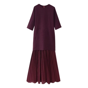 Détail d'une robe bordeaux avec ourlet plissé et texture en maille sophistiquée