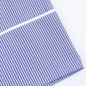 Gros plan sur la poche avec surpiqûre précise sur tissu à rayures bleues et blanches