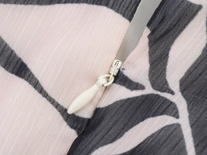 Detail of invisible zipper and leaf print on chiffon dress with vertical texture