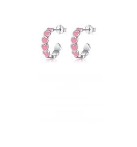 Macro shot of S925 sterling silver hoop earrings featuring five pink heart charms