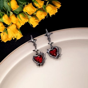 Dark gothic silver heart earrings with red zircon and star drop on cream tray