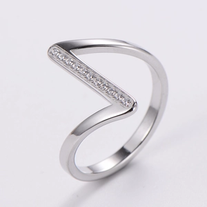 Macro shot of silver V-shaped ring with pavé set cubic zirconia stones on gray background