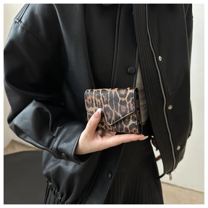 Mini pochette a busta chic con stampa leopardata tenuta da modella in giacca nera