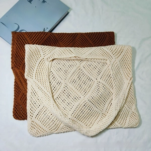 Detailed macro of geometric hollow-out knit pattern on brown and beige tote bags