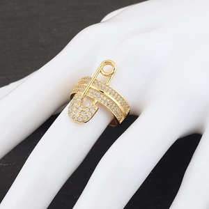 Detail of gold safety pin ring with micro-pave zircons worn on model's finger