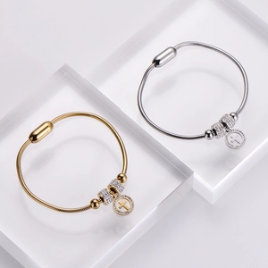 Gold and silver snake chain bracelets with diamond-encrusted charms and magnetic clasp