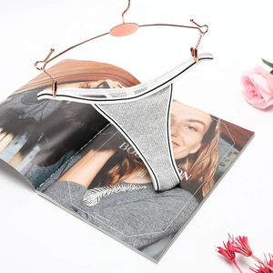 Gray ribbed low-rise cotton thong on rose gold hanger with fashion magazine and floral decor