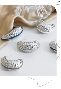 Detailed view of silver plated titanium steel hoop earrings with unique hammered texture