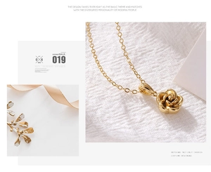 Detail of a 3D gold rose flower pendant necklace on white textured knit fabric