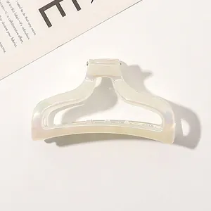 Macro detail of a hollow trapezoid iridescent pearl white hair claw clip for women