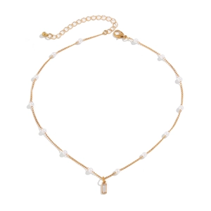 Detail of gold chain necklace with white pearls and a rectangular crystal pendant